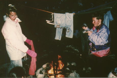 Britta und Nicole versuchen ihre Sachen über dem Feuer zu trocknen